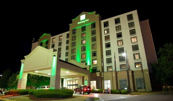 Welcome to the Holiday Inn, featuring a sleek entrance with a flat roof and windows on each floor.