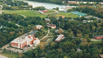 Vista aérea de un campus con varios edificios, áreas verdes y una masa de agua.