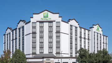 Holiday Inn -hotelli, jossa on valkoinen julkisivu, useita kerroksia ja keskeinen sisäänkäynti.