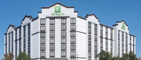 A Holiday Inn hotel with a white exterior, multiple floors, and a central entrance.