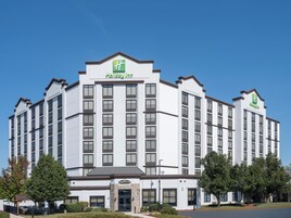 Un hotel Holiday Inn con fachada blanca, varios pisos y una entrada central.