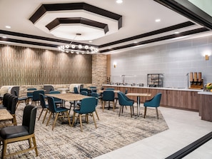 Eine moderne Hotelhalle mit verschiedenen Sitzbereichen, einem Buffet und einer Wand aus Stein.