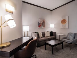 Una sala de estar moderna con un sofá, sillones, una mesa de centro y dos lámparas de pie.