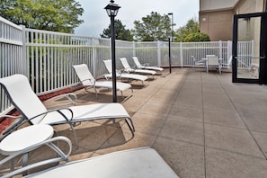 Relax in comfort on the patio, surrounded by lush greenery and a tranquil atmosphere.