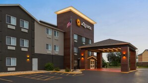 Een La Quinta hotel met een modern design, met een opvallende ingang met een overdekte doorgang en een parkeerplaats ervoor.