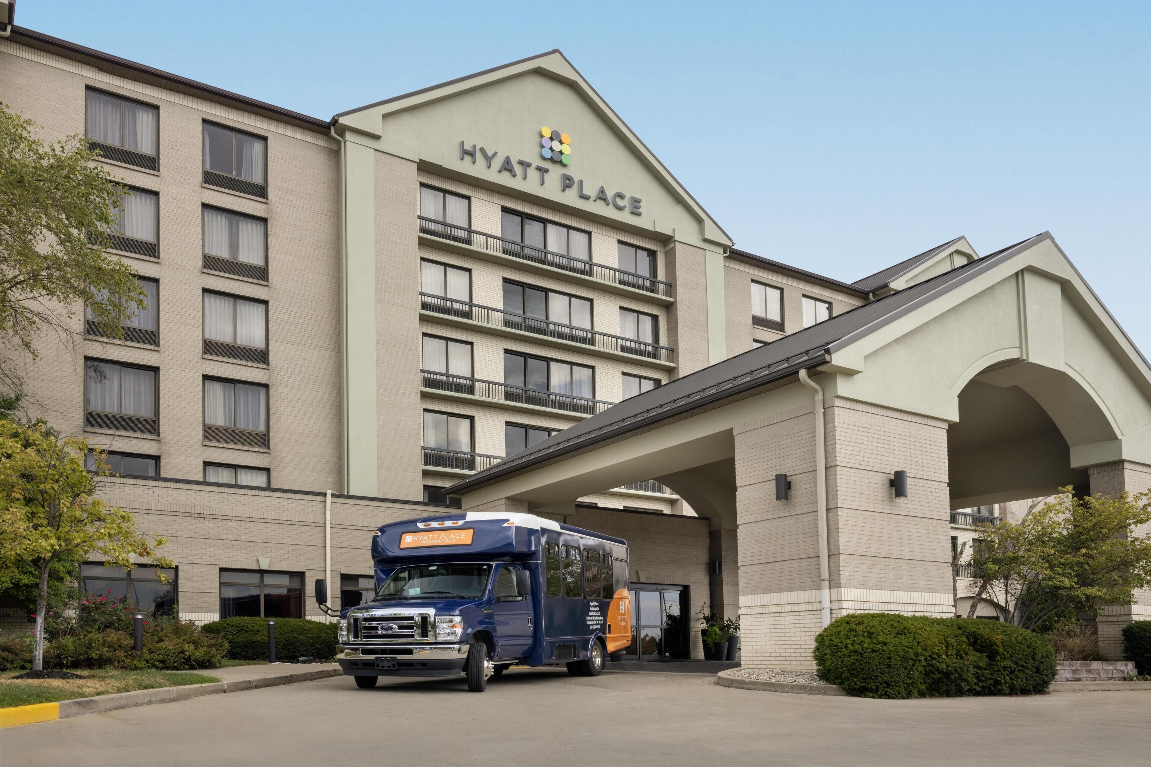 Een meerhoog gebouw met een bord waarop 'HYATT PLACE' staat en een bestelwagen die er geparkeerd is.