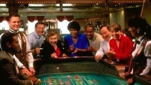 A group of people gathered around a casino table with chips and cards, indicating a gambling activity.
