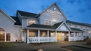 Radisson-ketjuun kuuluva Country Inn & Suites -hotelli, jossa on kaksikerroksinen rakennus, katettu kuisti ja pysäköintialue.