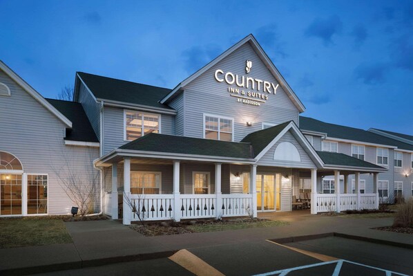 A Country Inn & Suites by Radisson with a two-story structure, a covered front porch, and a parking lot. - Country Inn & Suites by Radisson, Grinnell, IA (Grinnell)