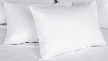 A bed with white bedding and pillows.
