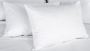 A bed with white bedding and pillows.