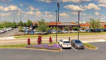 A parking lot with several cars, a building with a sign, and a clear sky.