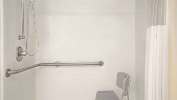Un bagno con doccia, maniglie di sostegno e uno sgabello.