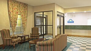 A lobby with striped armchairs, a sofa, a coffee table, and a checkered floor. - Days Inn by Wyndham Hammond (Hammond)