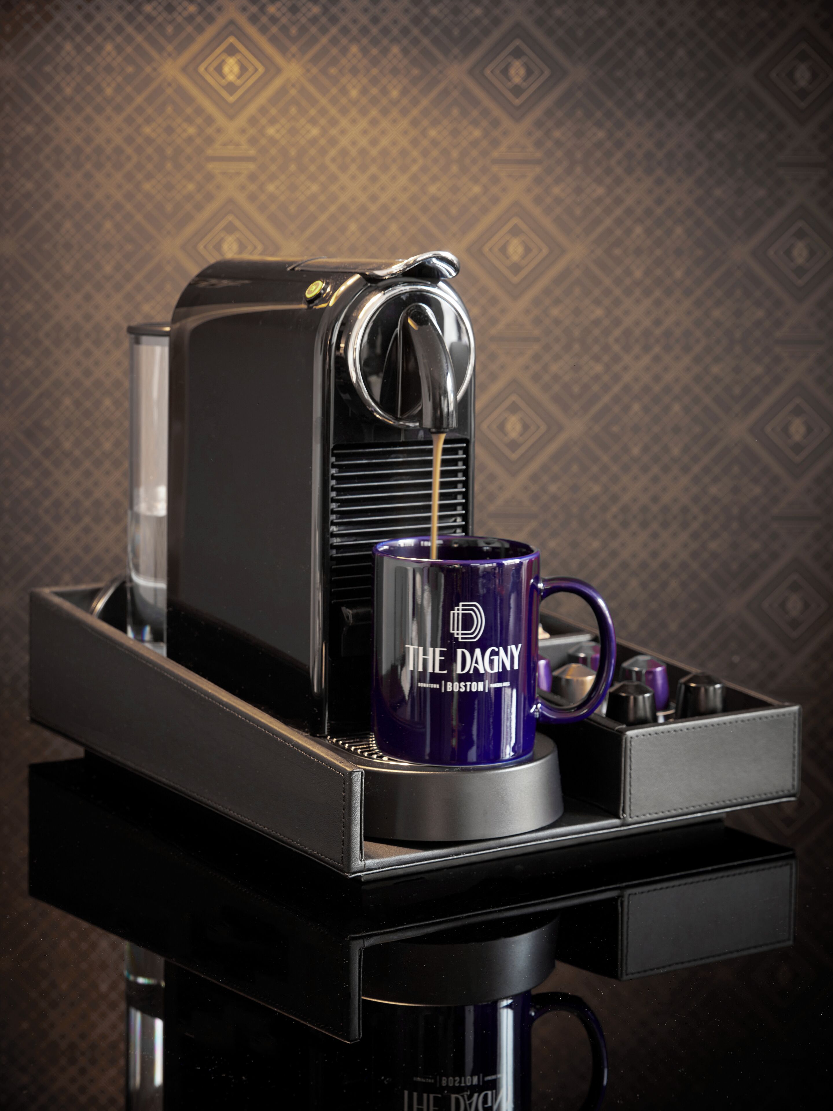 A coffee machine with a purple mug labeled "The Dagny" on its drip tray.