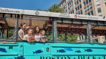 A teal bus with fish decals and the text "BOSTON DUCK TOUR" and "Tickets & Departures Museum of Science."