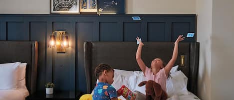 Ein Hotelzimmer mit einem Bett, einem Nachttisch mit Lampe und gerahmten Bildern an der Wand.
