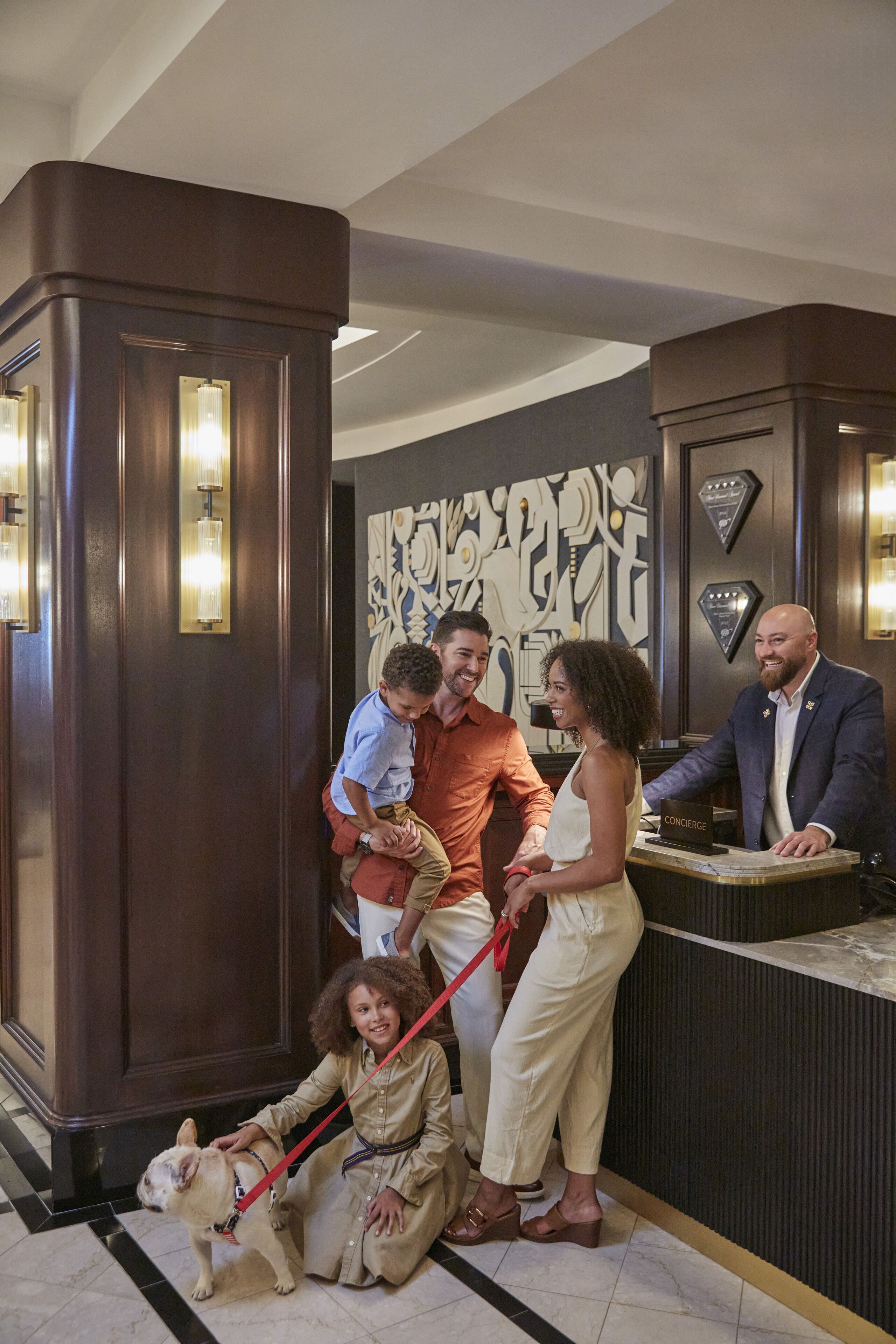 A hotel reception area with a reception desk, a large decorative wall, and a reception counter.
