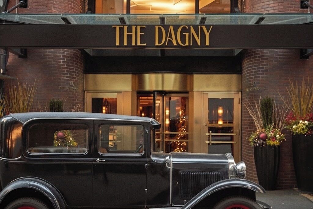 Un coche negro antiguo estacionado frente al hotel Dagny.