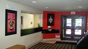 Un área de recepción con mostrador, un banco, un número '4' enmarcado en la pared y un letrero que indica 'EXIT'.