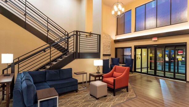Un hall con escaleras, zona de estar y mostrador de recepción.