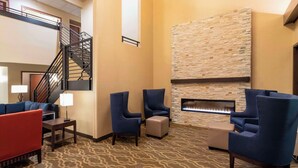 Un hall con chimenea, zona de estar y escalera.