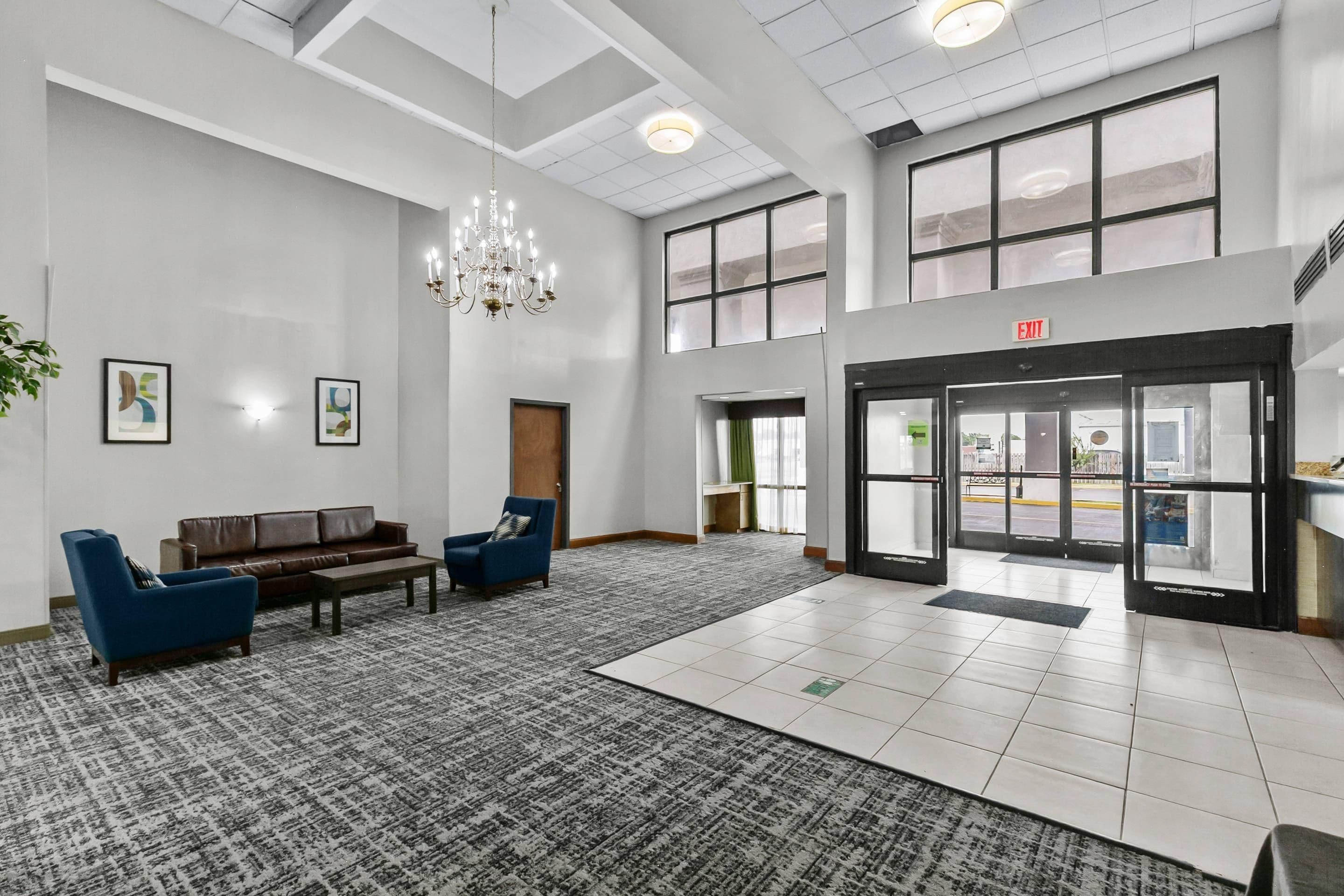 A lobby with a chandelier, seating area, and a reception desk.
