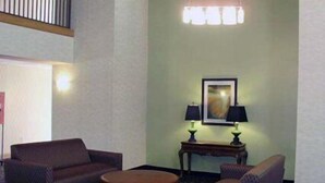 A lobby with two armchairs, a round ottoman, a small table with two lamps, and a framed artwork on the wall. - Quality Inn Clarksdale (Clarksdale)
