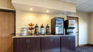 A self-service beverage station with various drink dispensers and a refrigerator. - Quality Inn Clarksdale (Clarksdale)