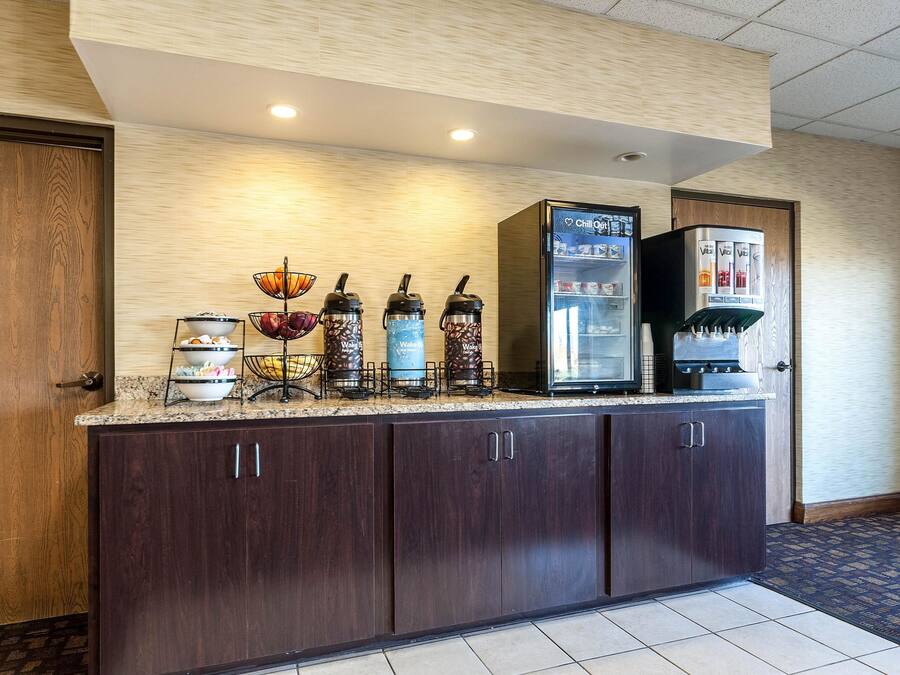A self-service beverage station with various drink dispensers and a refrigerator.