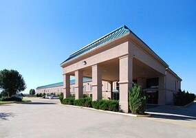 A hotel with a covered outdoor area, columns, and a clear sky.