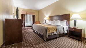 A hotel room with a bed, bedside tables, a desk, and a chair. - Quality Inn Clarksdale (Clarksdale)