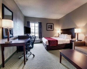 A hotel room with a bed, desk, chair, and a television. - Columbia Inn & Suites (Columbia)