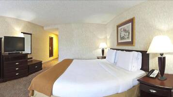 Una habitación de hotel con cama, televisión, escritorio y lámpara.