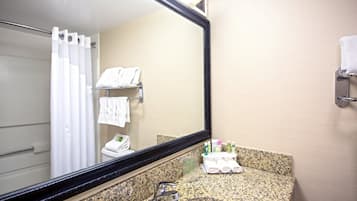 Baño con lavamanos, espejo y toallero.