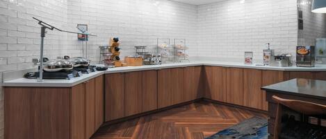 A modern kitchen with white subway tiles, wooden cabinets, and a herringbone-patterned floor.