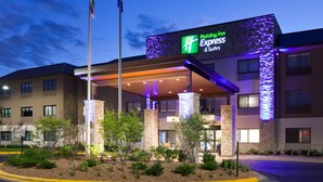 A Holiday Inn Express & Suites building with a modern exterior, stone pillars, and a covered entrance area. - Holiday Inn Express & Suites Omaha - 120th and Maple by IHG (Omaha)