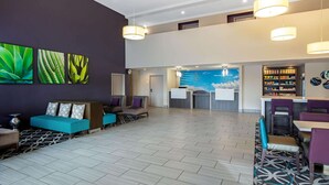 A spacious lobby with a reception desk, seating area, and a patterned floor.