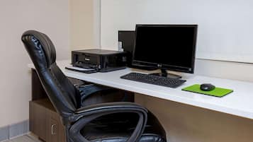 A modern office desk with a computer, keyboard, mouse, and printer.