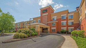 Un hotel Staybridge Inn con ingresso centrale, parcheggio e aree verdi curate con arbusti.