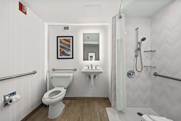 A modern bathroom with a toilet, sink, and shower.