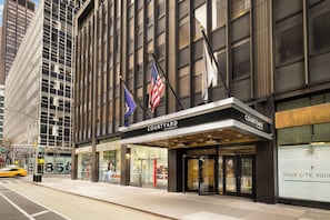 Un hôtel doté d’une façade moderne, de grandes fenêtres et d’une entrée imposante.