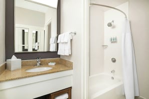 Une salle de bain équipée d’un lavabo, d’un miroir, d’un porte-serviettes et d’une douche.