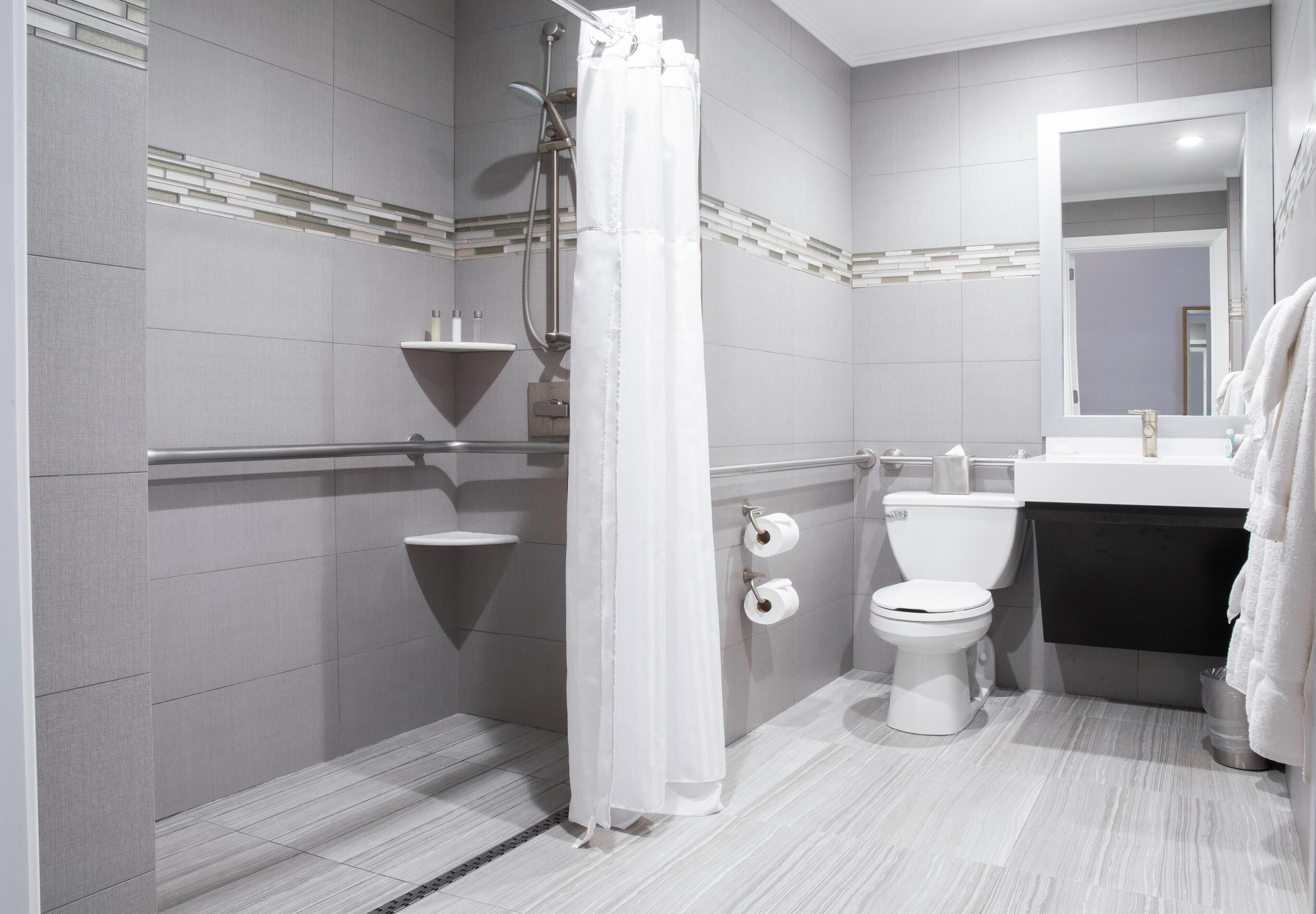 A modern bathroom with a shower, toilet, and sink.