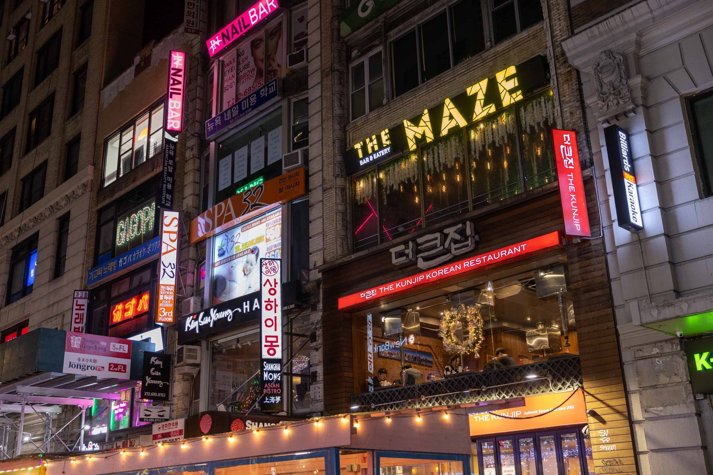 A building with multiple signs, including "The Maze Bar & Restaurant" and "KUNJIP KOREAN RESTAURANT".