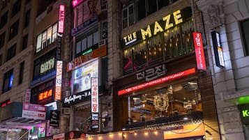 A building with multiple signs, including "The Maze Bar & Restaurant" and "KUNJIP KOREAN RESTAURANT".