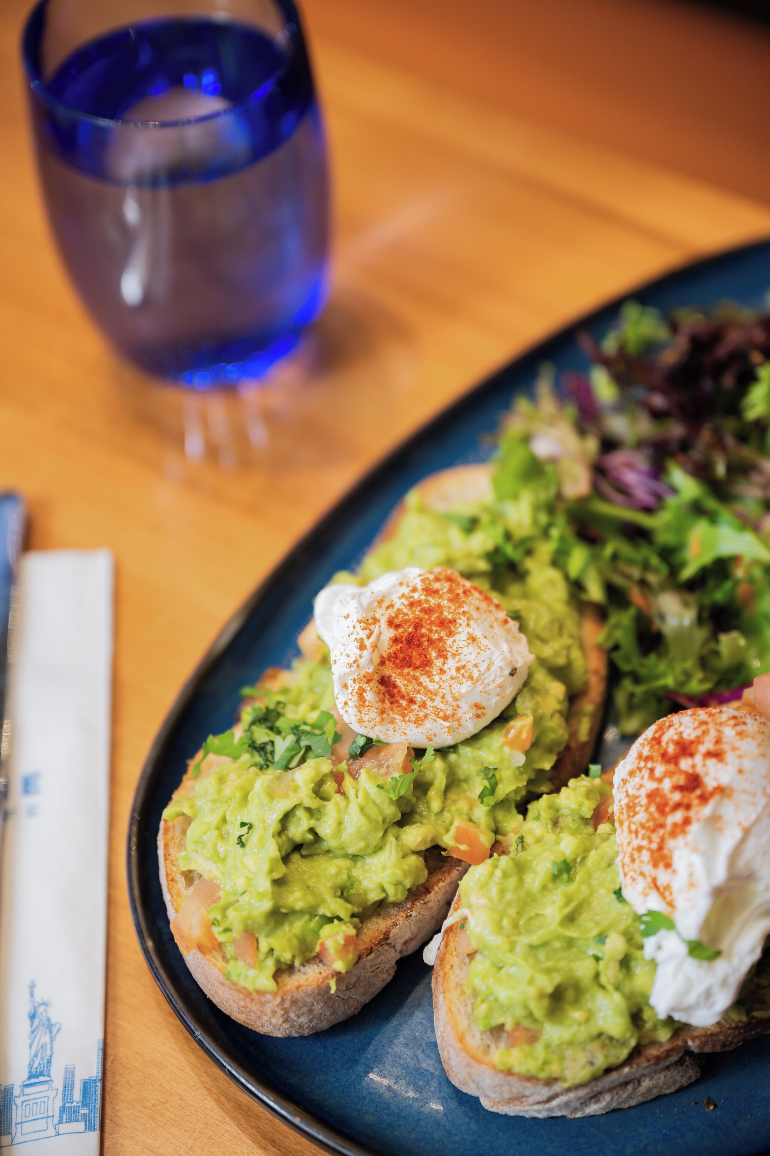 Ein Teller mit Avocado-Toast, belegtes Ei und einem kleinen Salat.