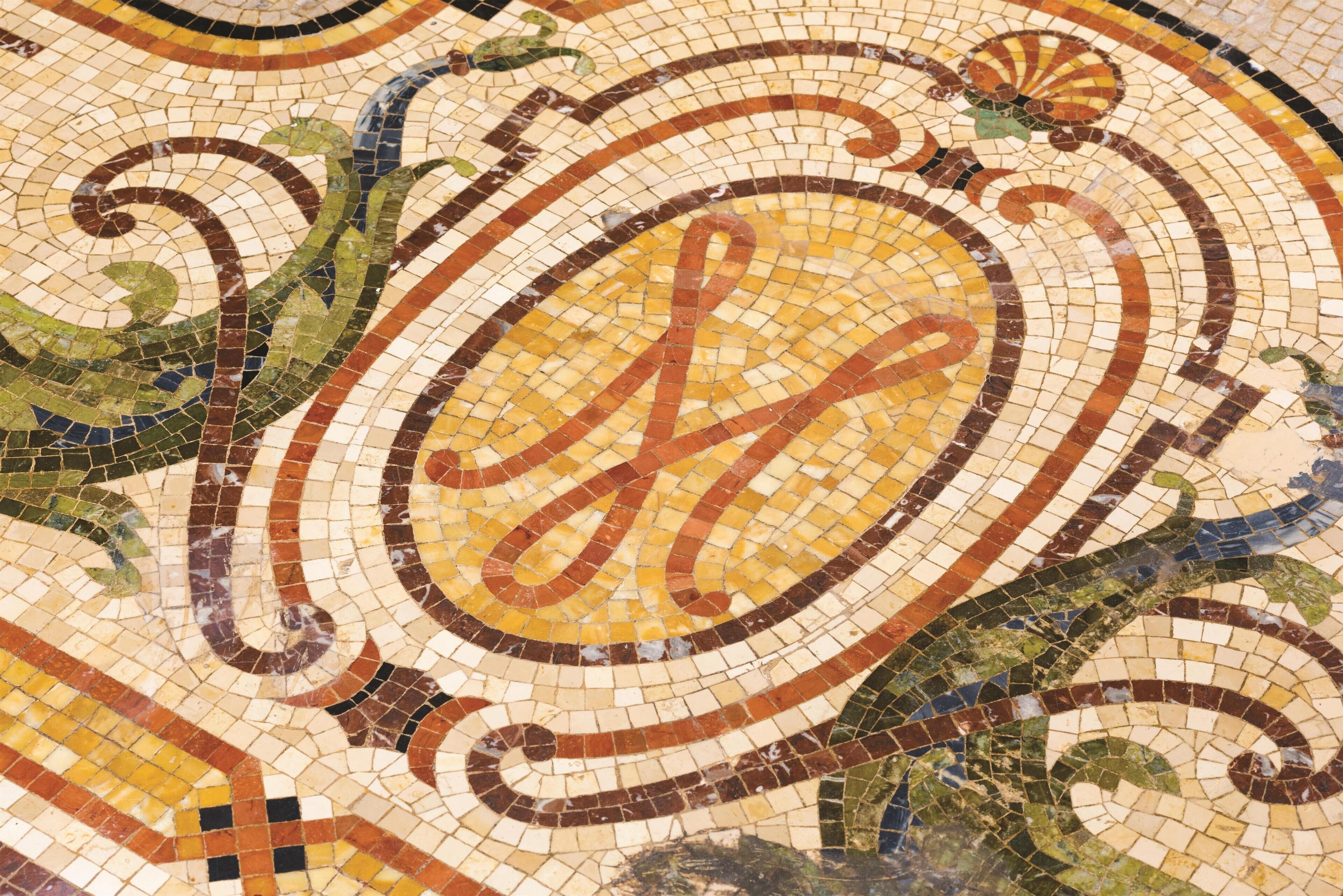 A detailed mosaic with a prominent letter 'H' in the center.