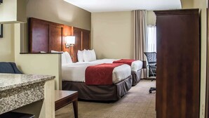 Ein Hotelzimmer mit Bett, Schreibtisch, Stuhl und Kleiderschrank.
