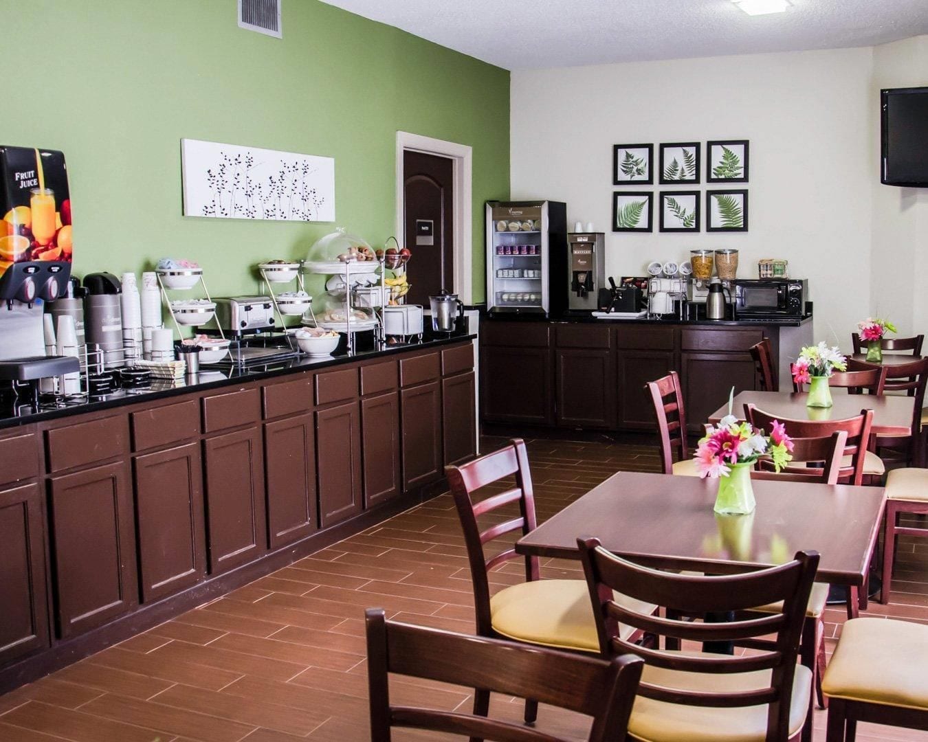A dining area with a buffet setup, a refrigerator, and a coffee station.